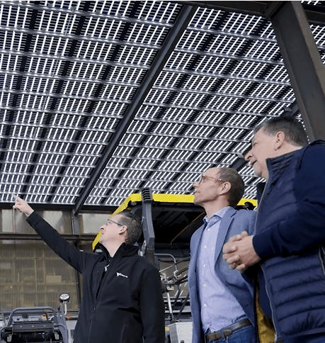 Les trois porteurs de projet regardent la toiture photovoltaïque dans la halle industrielle